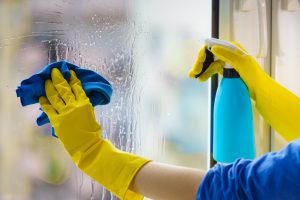 Female,Hand,In,Yellow,Gloves,Cleaning,Window,Pane,With,Rag