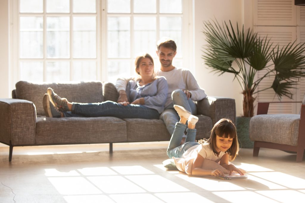 Happy,Parents,Relaxing,On,Couch,In,Comfort,Light,Living,Room
